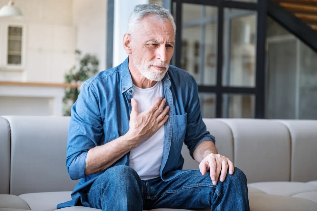 Adult on couch with hand on chest