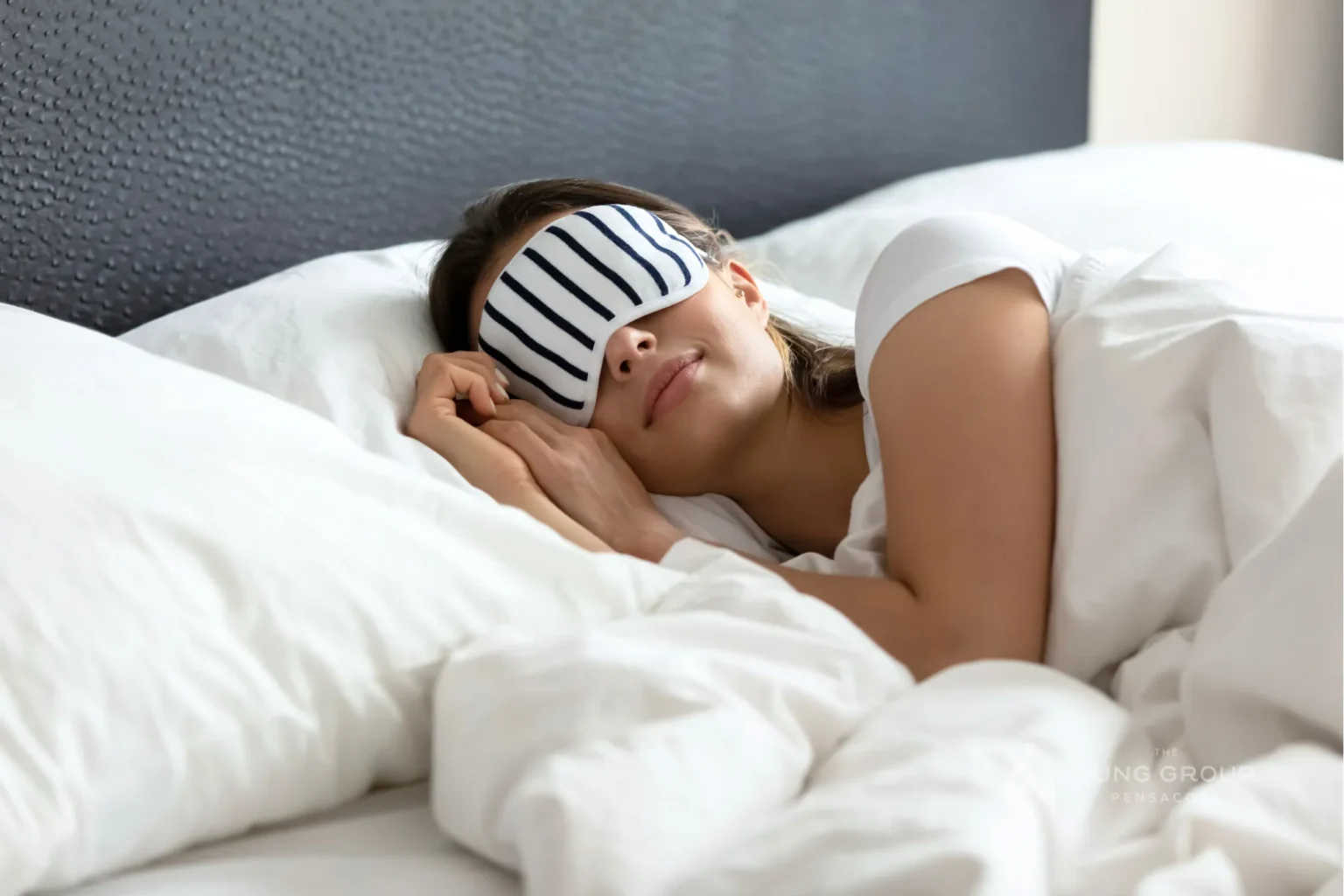 Woman sleeping with a black/white cover over eyes